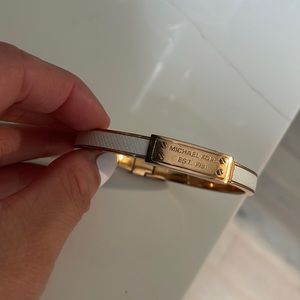 Michael Kors white bangle with rose gold accents and clasp closure